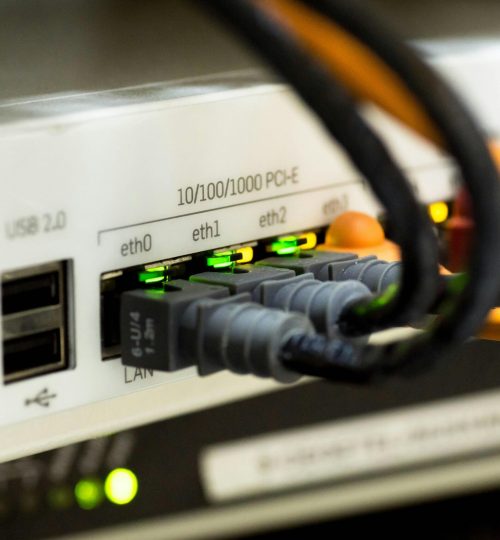 Detailed close-up of ethernet cables and network connections on a router, showcasing modern technology.