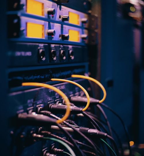 Close-up of network cables and ports in a server rack, showcasing connectivity.